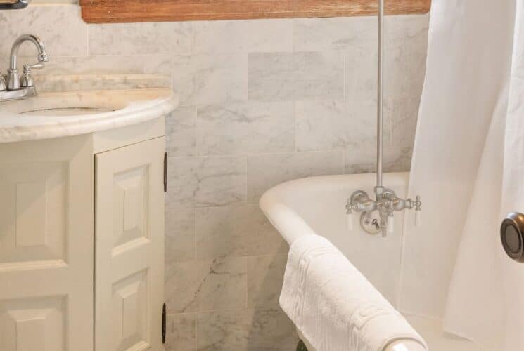 Bathroom with clawfoot tub, corner sink below a window